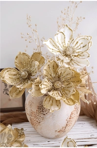 Detail of elegant artificial Christmas flowers with gold sequins in a ceramic vase
