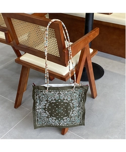 Detail of bohemian tote bag with paisley print and colorful beaded shoulder strap