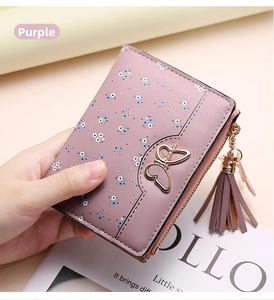 Detail of purple floral wallet with golden butterfly clasp and stylish tassel zipper