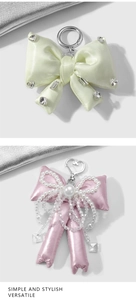 Detail of satin bow keychains with sparkling rhinestones, pearls and heart metal clasps
