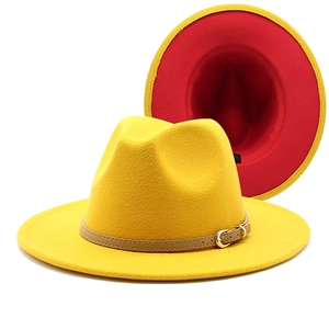 Detail of wool fedora hat showing yellow exterior and red lining with leather band buckle