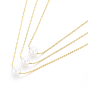 Minimalist gold snake chain layered necklace with white round pearls on white background