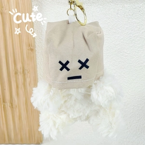 Détail de porte-clés chien Westie en peluche avec capuche beige et fermoir doré