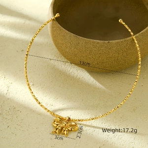 Close-up of golden bow pendant necklace with detailed size and weight specifications