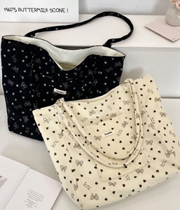 Detailed corduroy tote bags in beige and black with heart and bow patterns