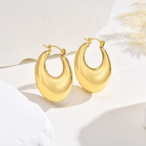 Detailed view of chunky gold teardrop earrings with a mirror-polished finish and latch back
