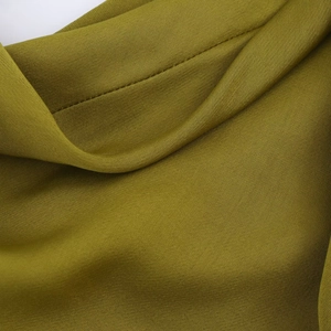 Detailed macro view of olive green satin fabric texture with soft drapes and subtle luster
