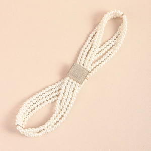Detailed macro view of multi-strand pearl belt with a sparkling rhinestone buckle accent