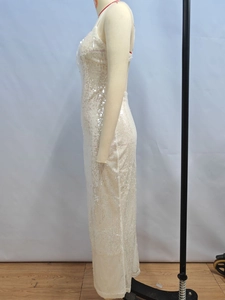 Detail of white sequin texture and floor-length slim fit cut on a backless evening gown