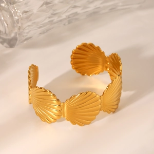 Détail d'un bracelet jonc en acier inoxydable plaqué or 18 carats avec motif coquillage