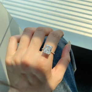 Macro vista di un grande anello con diamante rettangolare e fascia con pavé di diamanti