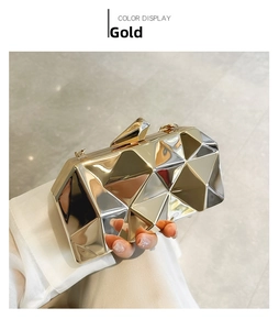 Detail of the geometric acrylic clutch bag with gold mirrored finish and diamond clasp