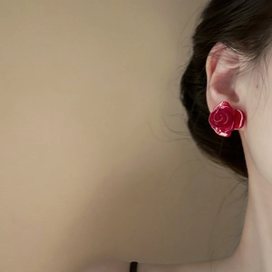 Close-up of a model wearing a glossy red resin rose earring with a minimalist vintage design