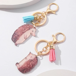 Detailed macro view of hedgehog acrylic keychains with colorful tassels and golden clasps