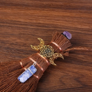 Detailed close-up of Wicca altar broom with amethyst, sodalite, and triple goddess symbol