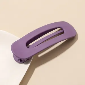 Close-up of matte purple rectangular hair clip with a minimalist hollow design