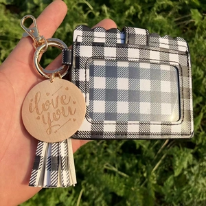 Detail of black and white checkered card holder with tassel and engraved wooden tag