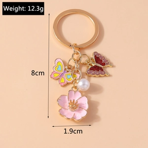 Detail view showing dimensions of floral butterfly keychain with pearl and pink charms
