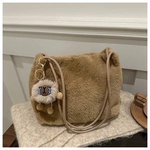 Brown faux fur shoulder bag detail with cute cartoon sheep charm and soft plush texture