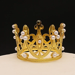 Elegant gold cake topper crown with heart cutouts and white pearls on black background