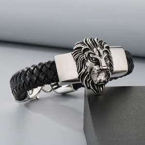 Close-up of the detailed silver lion head relief on a black braided leather bracelet