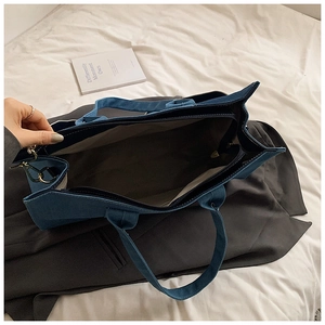 Interior detail of large blue denim tote bag showing spacious lining and zipper closure