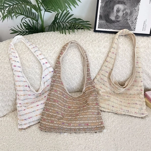 Detail showing colorful knit tote bags with shell charms and bohemian crochet texture