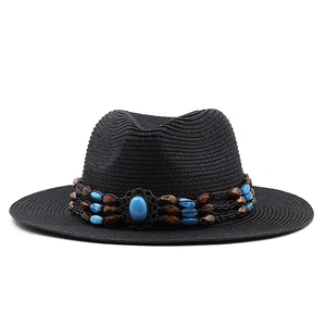 Détail d'un chapeau de paille noir avec ruban perlé ethnique turquoise et pierre vintage