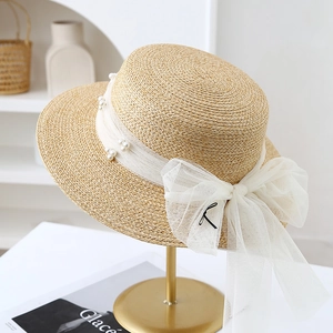 Detailansicht Strohhut in Beige mit weißem Netzband, Perlen und bestickter Schleife