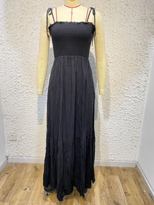 Detailed view of elastic smocked bodice and adjustable bow straps on black maxi dress