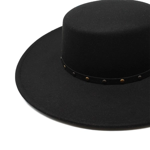 Detail of black flat top wool felt hat with decorative metal studs on the brim