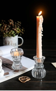Close-up of elegant ribbed glass candle holders on a vintage wooden tabletop