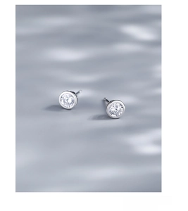 Detail of round S925 sterling silver stud earrings featuring sparkling cubic zirconia