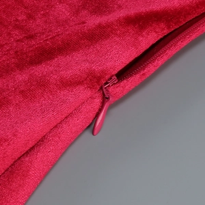 Detail of invisible zipper on elegant red velvet dress with fine stitching and soft texture