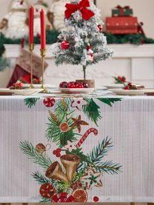 Vista detallada de un camino de mesa navideño con campanas y motivos de pino festivos