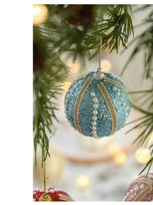 Close-up of blue glitter Christmas ball with pearls hanging on a festive tree branch