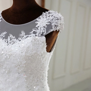 Detail of white bridal gown featuring intricate floral lace and sequins on sheer mesh