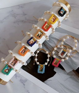 Detailed shot of handmade religious bracelets featuring natural pearls and colorful beads.