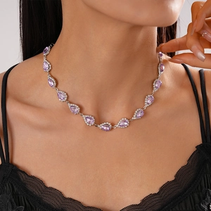 Close-up of luxury lavender waterdrop necklace with sparkling diamonds on a model