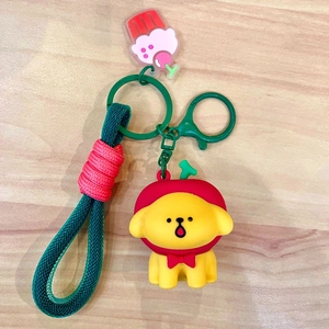Detail view of cartoon dog keychain with red hoodie, green snap hook and braided strap