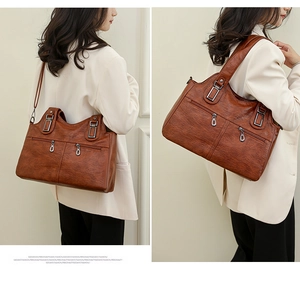 Detail of brown faux leather texture and silver square hardware on a large shoulder bag