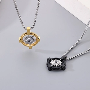 Detailed close-up of gold and black compass pendants in polished stainless steel