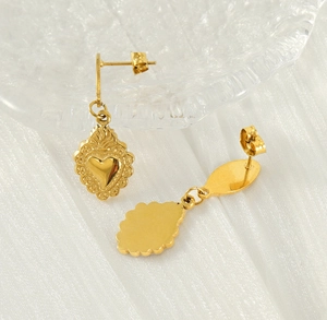 Macro shot of gold-plated titanium heart earrings featuring embossed wave textures