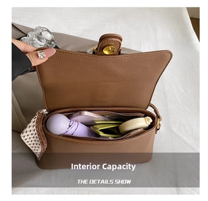 Internal view of brown leather shoulder bag showing storage for umbrella and phone