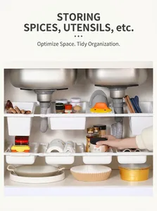 Detail of adjustable under-sink storage rack showing multiple white plastic basket layers