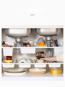 Detail of adjustable under-sink storage rack showing multiple white plastic basket layers