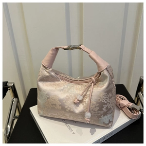 Detail of pink brocade handbag with traditional landscape pattern and tassel charm
