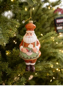 Gingerbread style Santa chef ornament with green apron on a festive Christmas tree