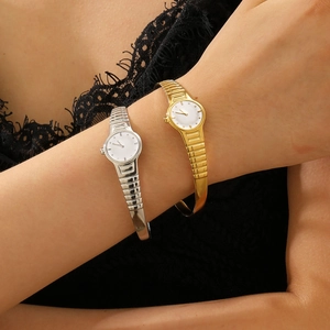 Detail of vintage gold and silver watch-style rings on hand with black lace