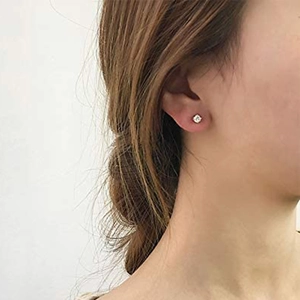 Close-up of minimalist S925 silver stud earring with sparkling diamond on earlobe